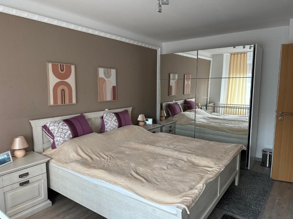 a bedroom with a large bed and a mirror at Ferienhaus Morgenstern in Wilhelmshaven