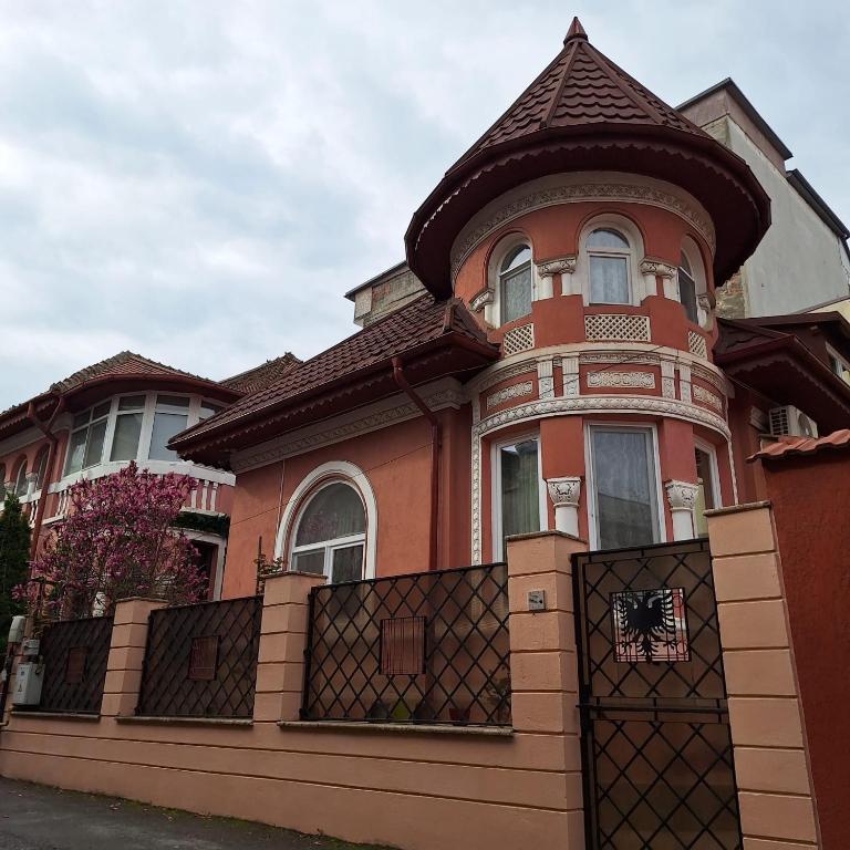 a large red house with a fence in front of it at Villa ANMA in Bucharest