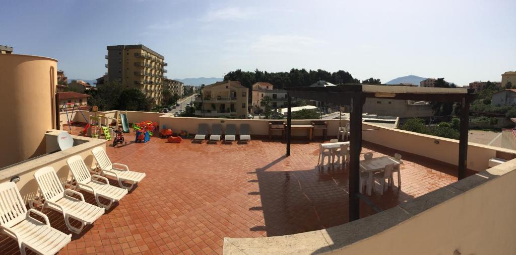 a patio with white chairs on a roof at Villa Gelvi in Castellammare del Golfo