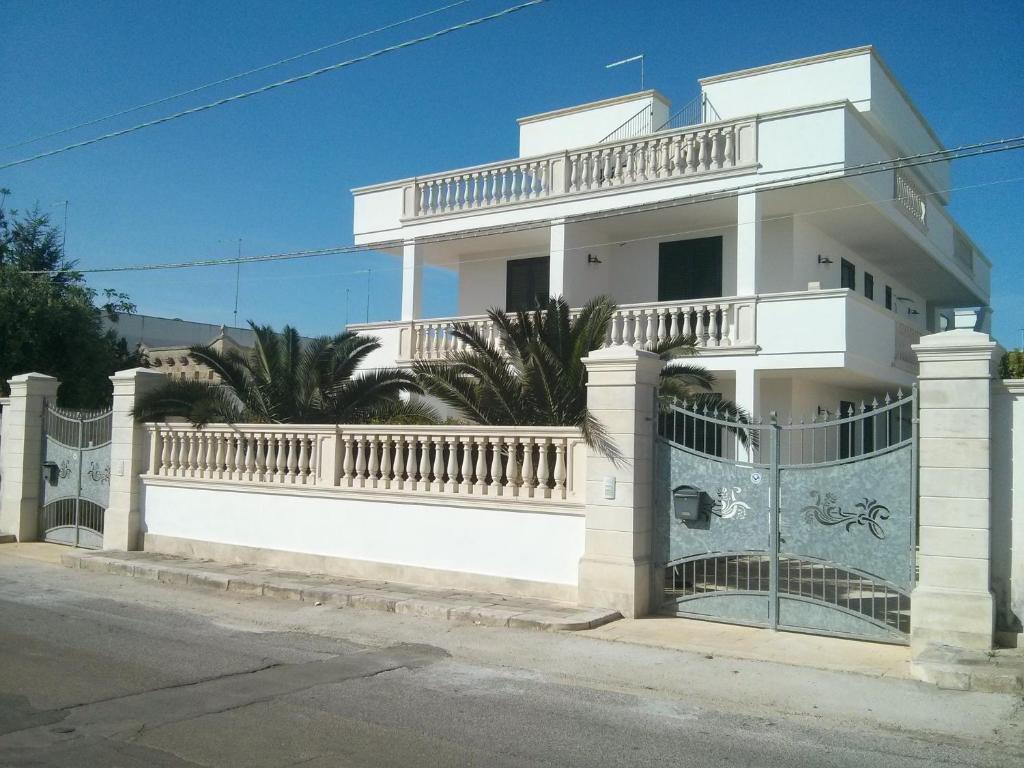 uma casa branca com uma cerca de ferro forjado em Dimora Liccisa em Torre Lapillo