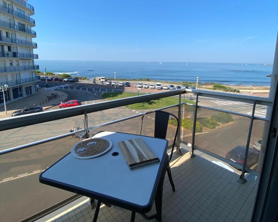 - une table sur un balcon avec vue sur l'océan dans l'établissement L'arbre du voyageur, à Les Sables-dʼOlonne