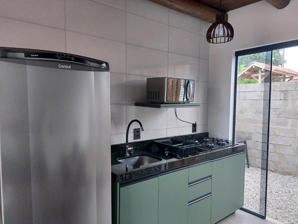 a kitchen with a sink and a stove at Casa da Paz -Praia do Rosa in Imbituba
