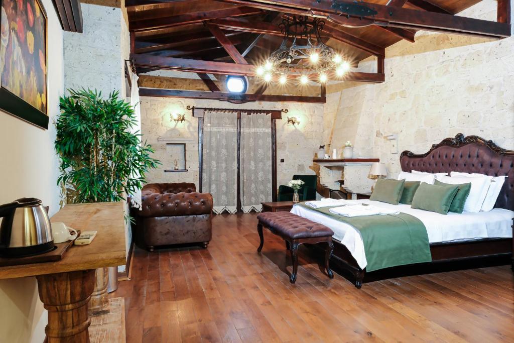 a bedroom with a bed and a couch and a table at Mai Alaçatı in Cesme