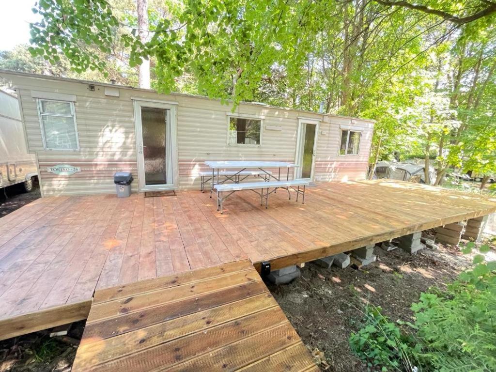 a wooden deck with a picnic table on top at Your Camp Kormoran Domek Holender in Hel