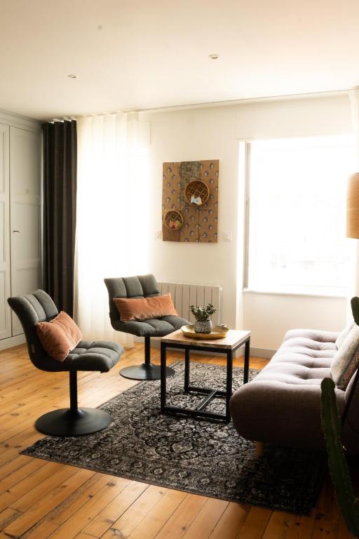 a living room with two couches and a table at Villa Bel-Amy in Saint-Pair-sur-Mer