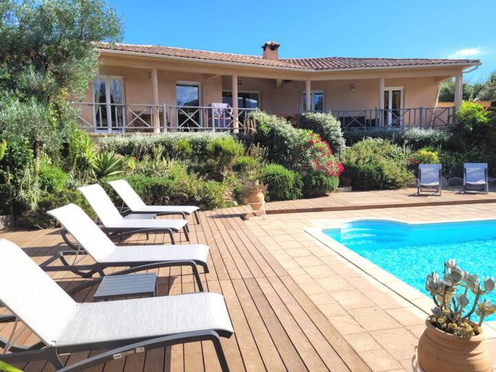 un groupe de chaises assises à côté d'une piscine dans l'établissement Villa à Porto-Vecchio - Résidence privé, à Porto-Vecchio