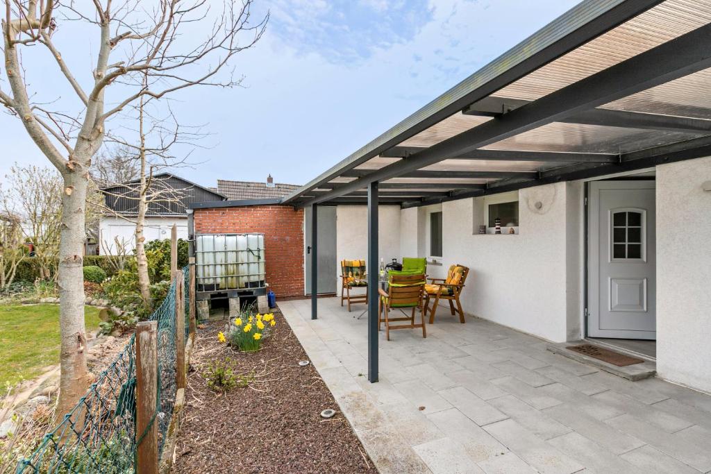 a pergola over a patio with a table and chairs at Ferienhaus Angela in Neuenkirchen
