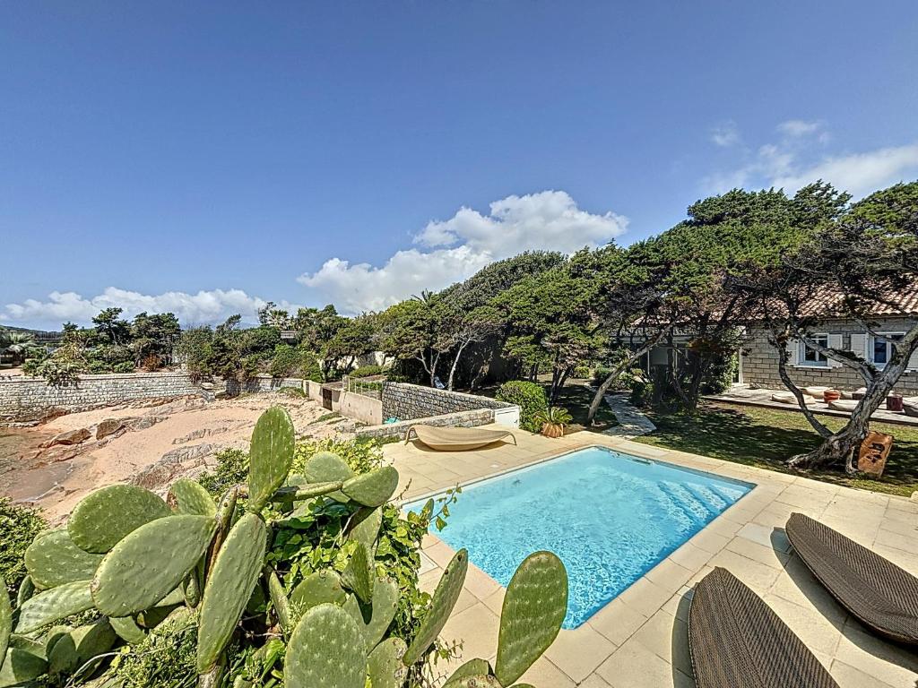 - une piscine dans une cour à côté d'une plage dans l'établissement La Perle d'Isolella - Villa Les Pieds dans l'Eau - Les Frères de la Loc', à Pietrosella