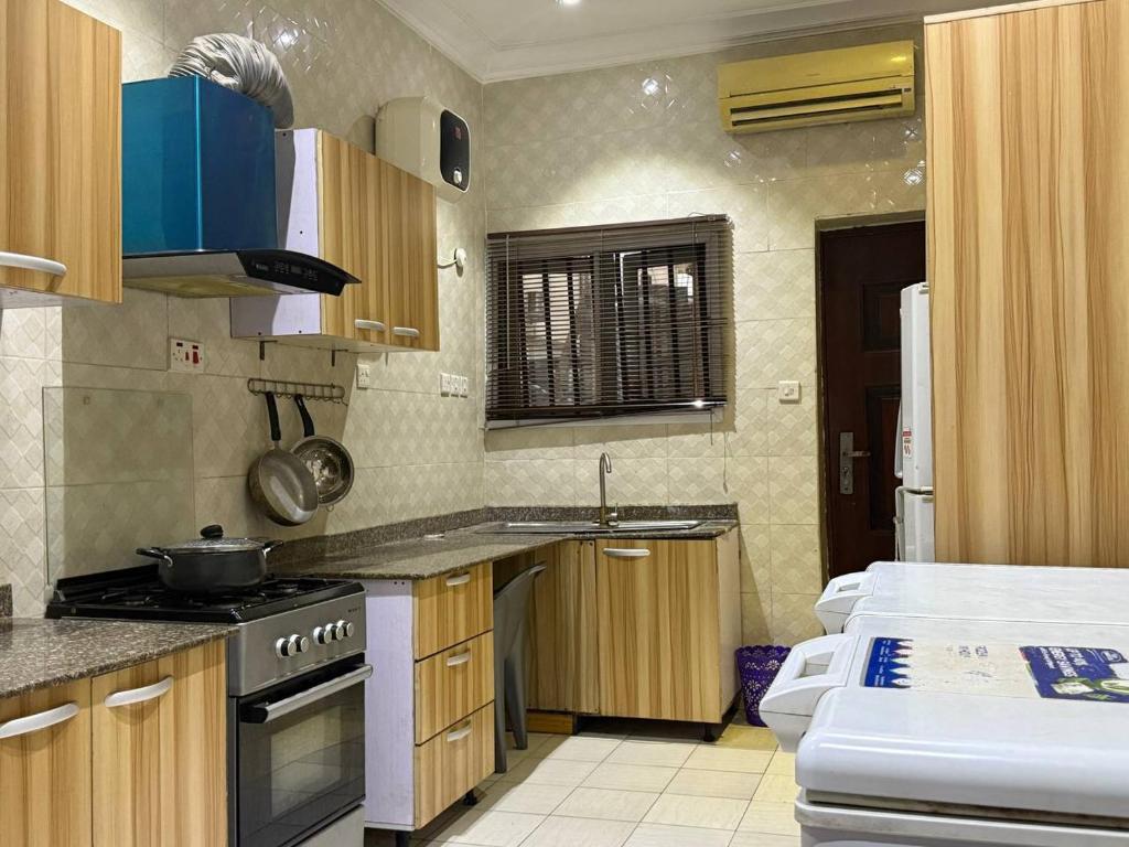 a kitchen with a stove and a sink in it at 1 bedroom Shortlet Apt at Osapa London Lekki in Lagos