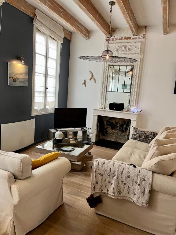 un salon avec un canapé et une cheminée dans l'établissement Family home Saint Martin de Ré intra-muros, à Saint-Martin-de-Ré