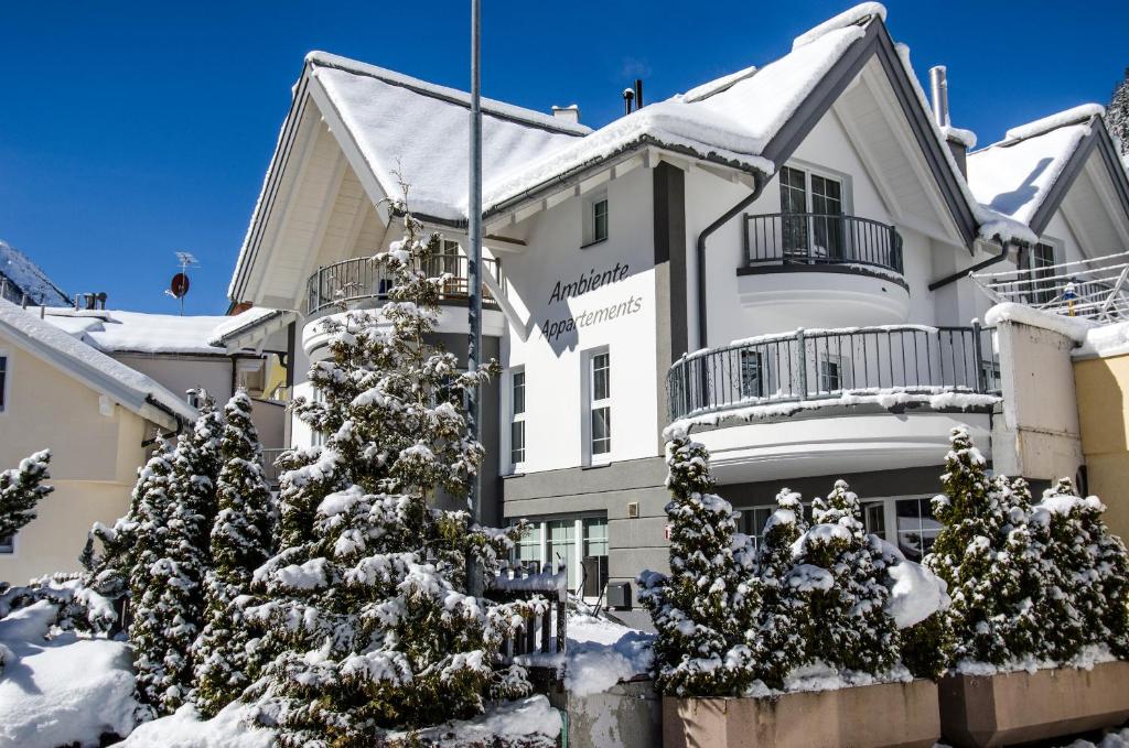 ein Gebäude mit schneebedeckten Bäumen davor in der Unterkunft Ambiente Appartements in Ischgl