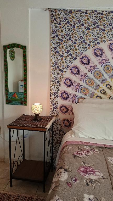 a bedroom with a bed and a table with a mirror at Hospedagem Namastê in Visconde De Maua