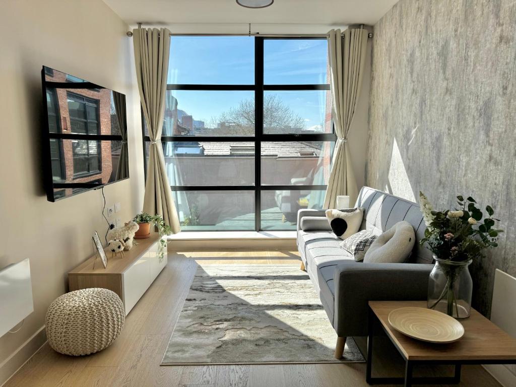Una sala de estar con un sofá y una ventana grande. en Homi Host- JQ inn, en Birmingham