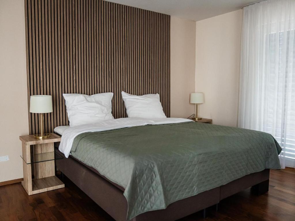 a bedroom with a large bed and two lamps at K&T Estates Resort & Spa, Frankfurt in Liederbach am Taunus