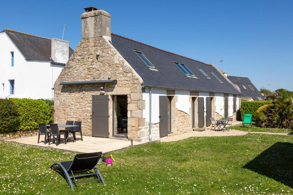 - un vieux bâtiment en pierre avec des chaises dans une cour dans l'établissement Ty Lorch, penty 4 pers - 150m plage, à Loctudy
