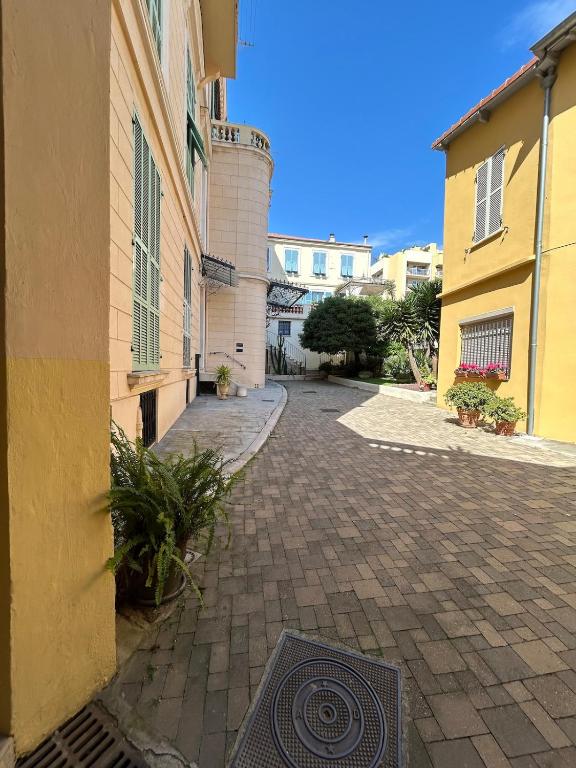 a brick walkway between two buildings in a city at Studio 50m de la mer in Menton
