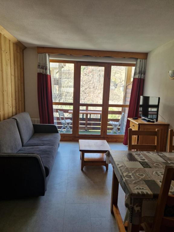 un salon avec un canapé et une table dans l'établissement Appartement F2 au pied des pistes, à Valloire