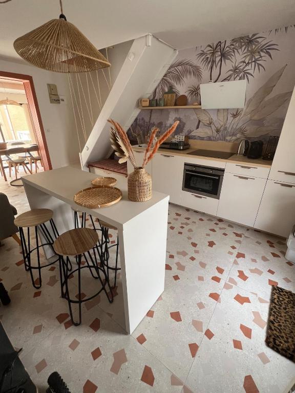 une cuisine avec un comptoir et des tabourets dans une pièce dans l'établissement Maison Terracotta des Karantes, à Narbonne-Plage
