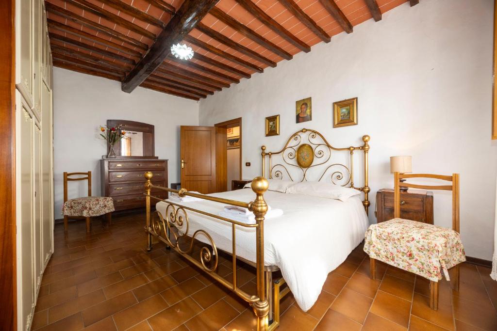 a bedroom with a white bed and a wooden ceiling at Tipica casa nelle Crete Senesi in Monteroni dʼArbia