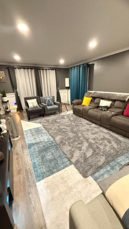 a living room with a couch and a large rug at Rooms available in a single Family home shared with Host in Willingboro