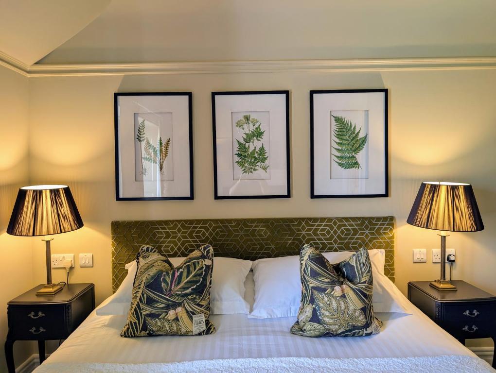 a bedroom with a bed with three pictures on the wall at Parc-Le-Breos House in Penclawdd
