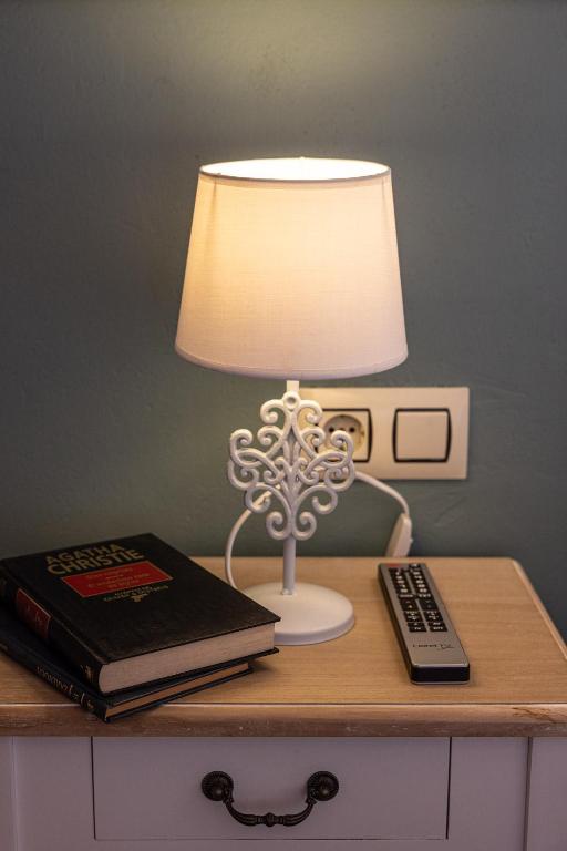 a lamp on a table with a book and a remote control at Hotel Puerto Arnela in Camariñas