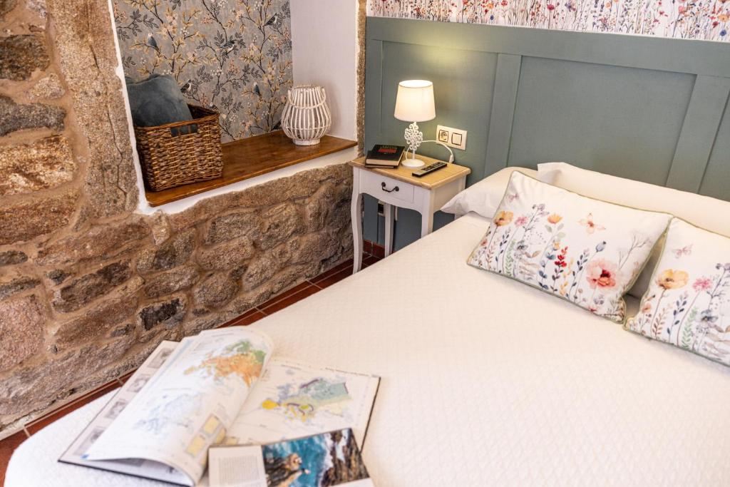 a bedroom with a bed with a book on it at Hotel Puerto Arnela in Camariñas