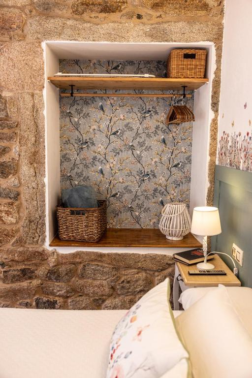 a bedroom with a stone wall with a wall mural at Hotel Puerto Arnela in Camariñas