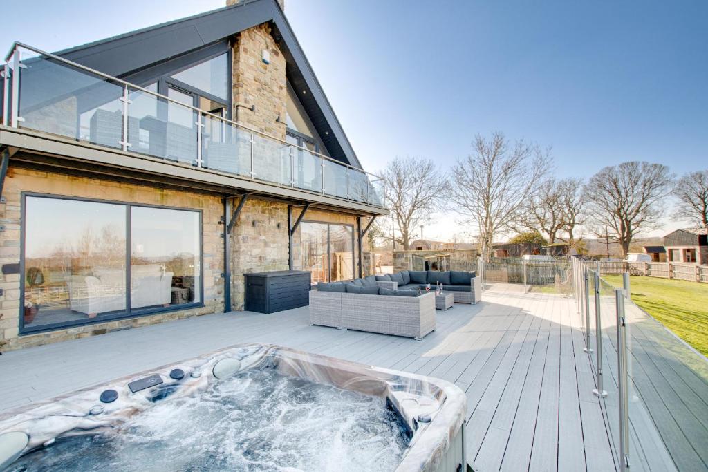 a house with a hot tub on a patio at Northern Hideaways Oakfield Lodge, Ponteland in Newcastle upon Tyne