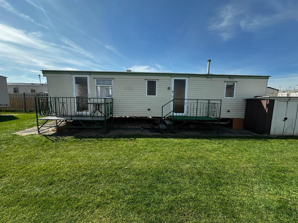 a white house with a porch and a yard at Golden Sands Park Ingoldmells in Ingoldmells