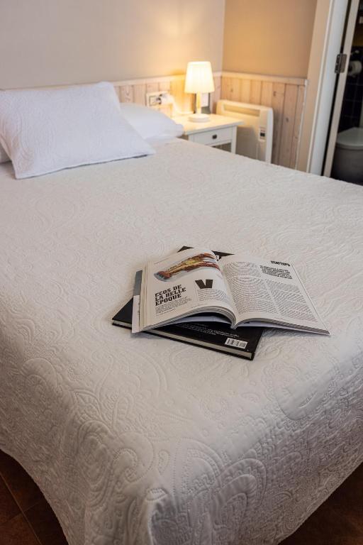 a book sitting on top of a bed at Hotel Puerto Arnela in Camariñas