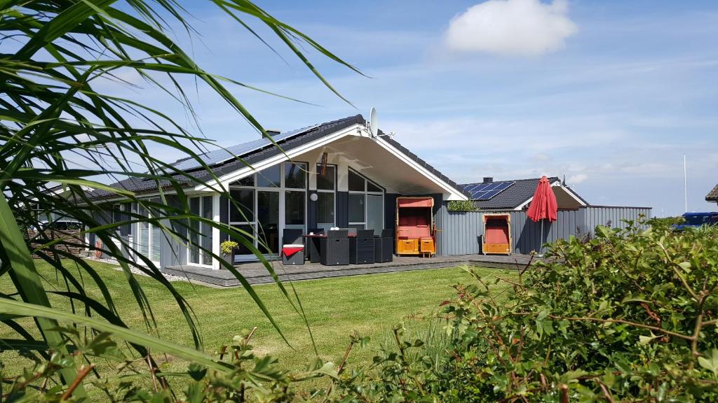 a house with a large window and a yard at Ferienhaus Nordseelicht in Wesselburenerkoog