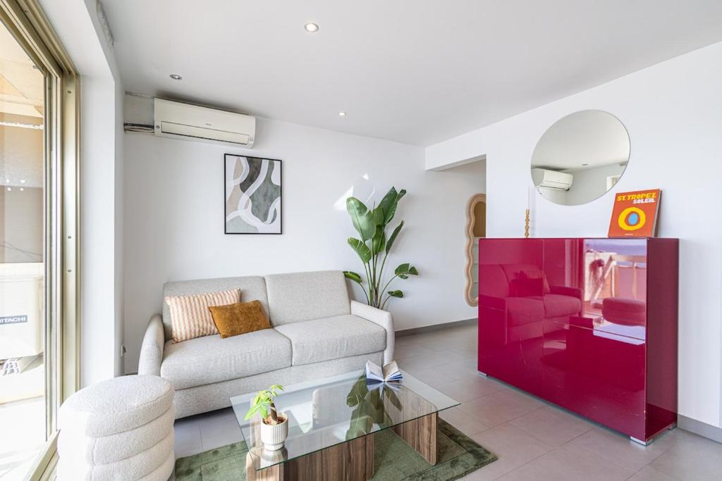 un salon avec un canapé et une table en verre dans l'établissement Stunning apartment with sea front terrace, à Saint-Laurent-du-Var