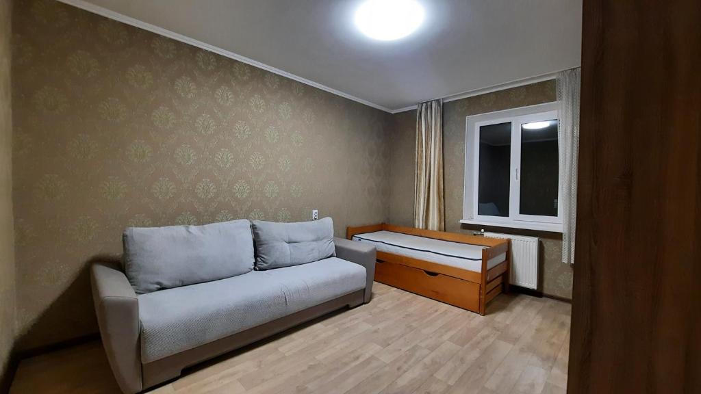 un soggiorno con un divano e una finestra di Двокімнатна квартиира з 4 ліжками кондиціонером та ванною Документи для відряджень a Poltava