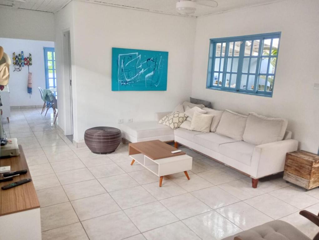 a living room with a white couch and a table at Família munhoz in Cananéia