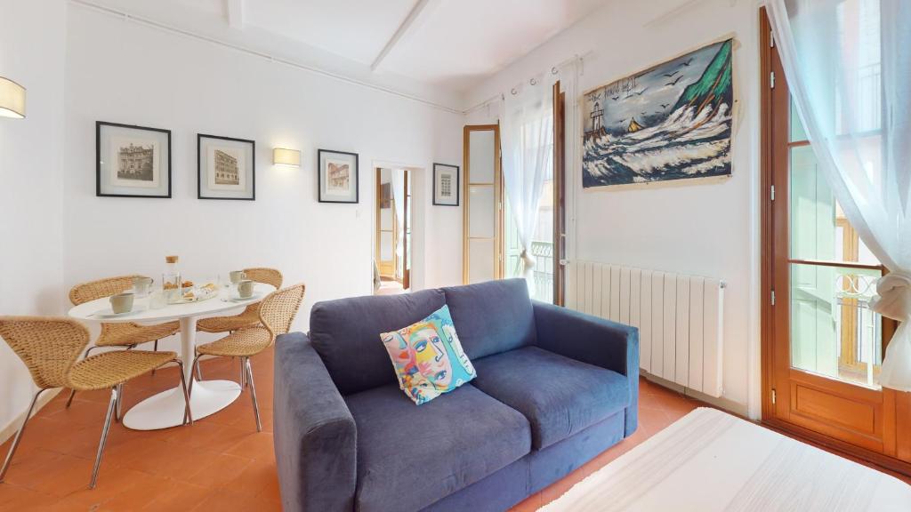 un salon avec un canapé bleu et une table dans l'établissement L'atelier de la rue Mailly, à Perpignan