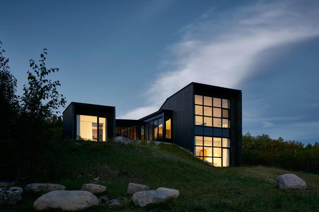 una casa en la cima de una colina por la noche en Villa La Charbonnière, en La Malbaie