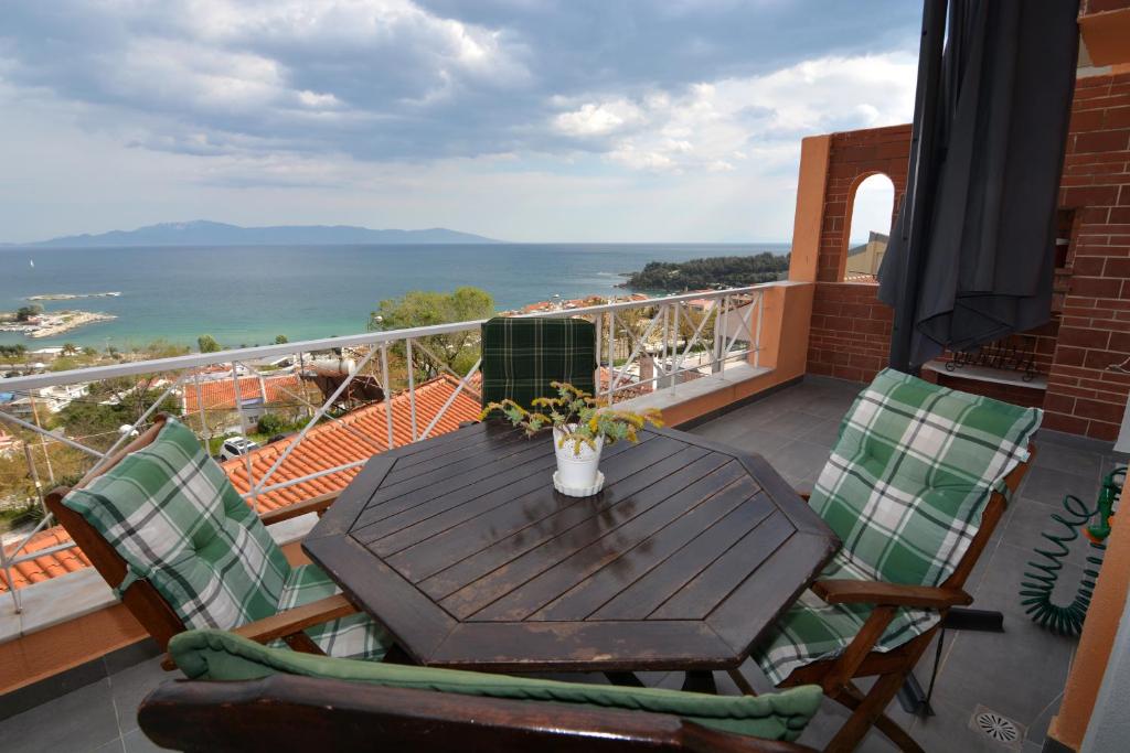 a table and chairs on a balcony with a view of the ocean at Apricot House in Kavála