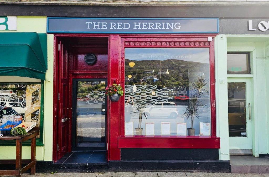 a red entrance to a store with a red door at The waterfront in Tarbert