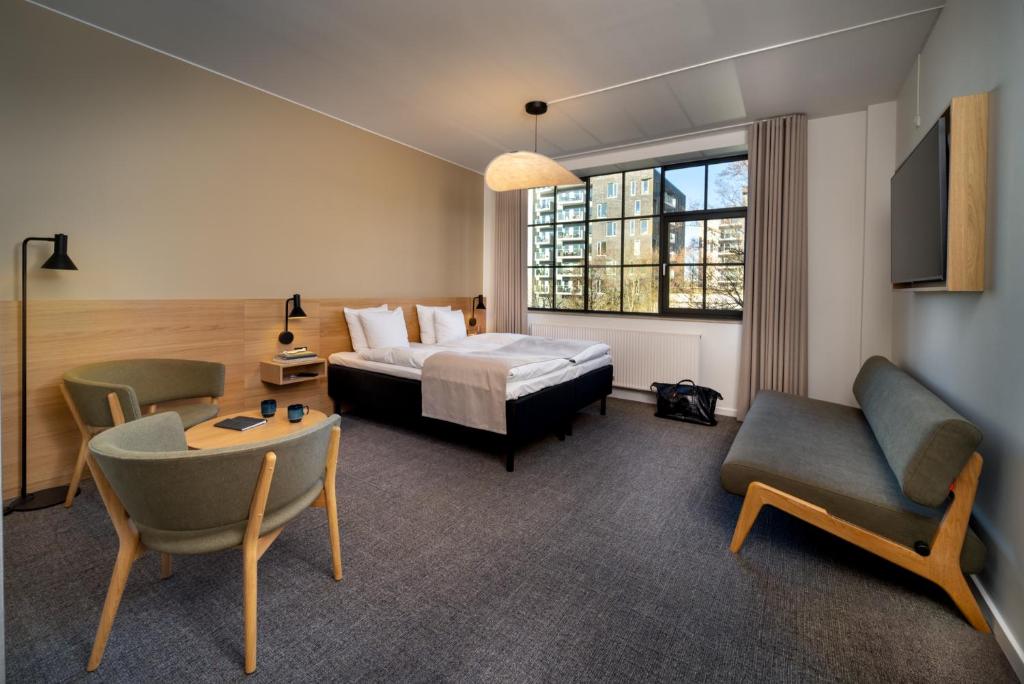 una camera d'albergo con letto, tavolo e sedie di Radisson Hotel Papirfabrikken Silkeborg a Silkeborg