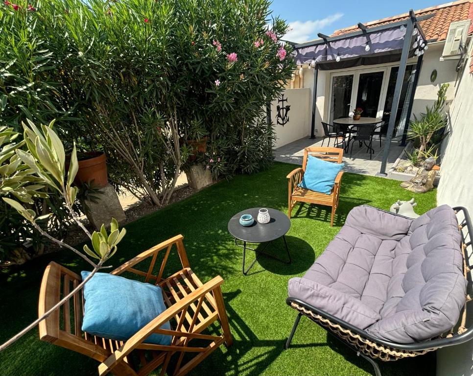 une cour avec des chaises, une table et un canapé dans l'établissement Sublime et paisible maison sur Bellegarde entre Nimes et Arles, à Bellegarde