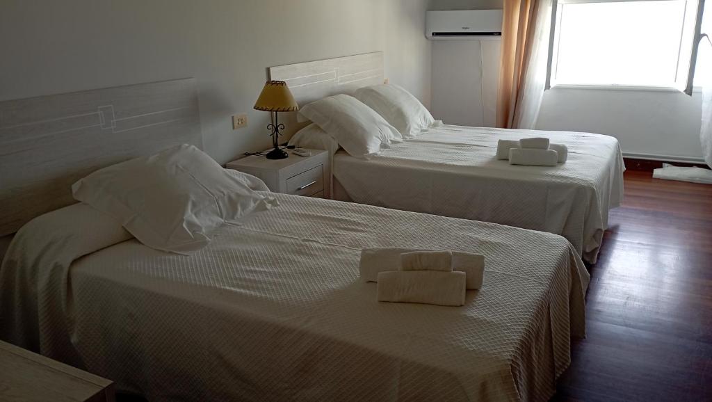 two beds in a hotel room with towels on them at Apartamento Planeta 2º centro in O Porto de Espasante