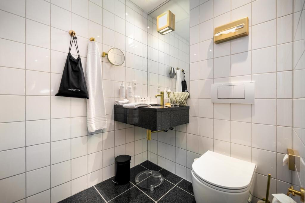 un bagno piastrellato bianco con servizi igienici e lavandino di Radisson Hotel Papirfabrikken Silkeborg a Silkeborg