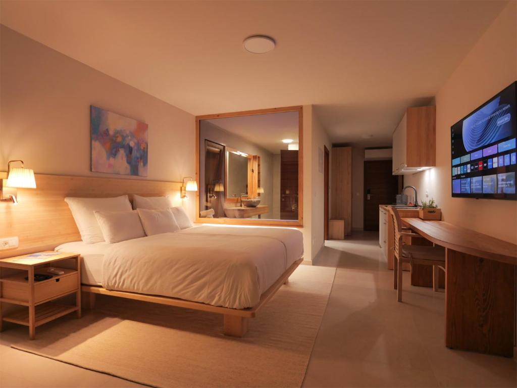 ein Hotelzimmer mit einem Bett und einem Fernseher in der Unterkunft Luxury Getaway for 2 Jacuzzi Studio at Villa Lojena ID111-7 in Murter