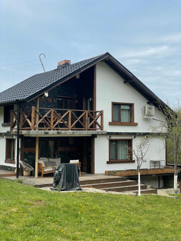 a large white house with a roof at Къща за гости Клонката in Dŭlbok Dol