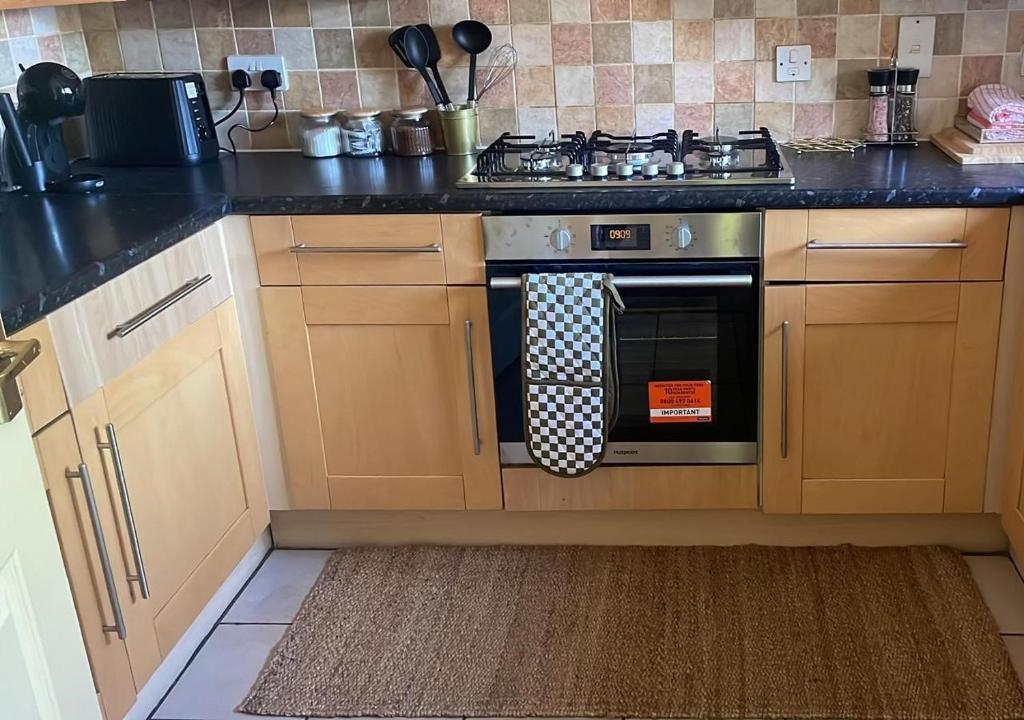 eine Küche mit einem Herd und einem Handtuch auf dem Ofen in der Unterkunft Modern 3 Bedrooms-Free Parking-Sleeps 8 in Kent