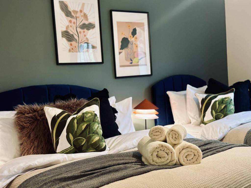 two beds with towels on top of them in a bedroom at Spacious 3 Bedrooms-Free Parking-Sleeps 8 in Kent