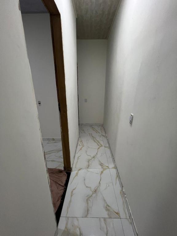 a hallway with marble floors and a door in a room at Eri House Home in Ananindeua