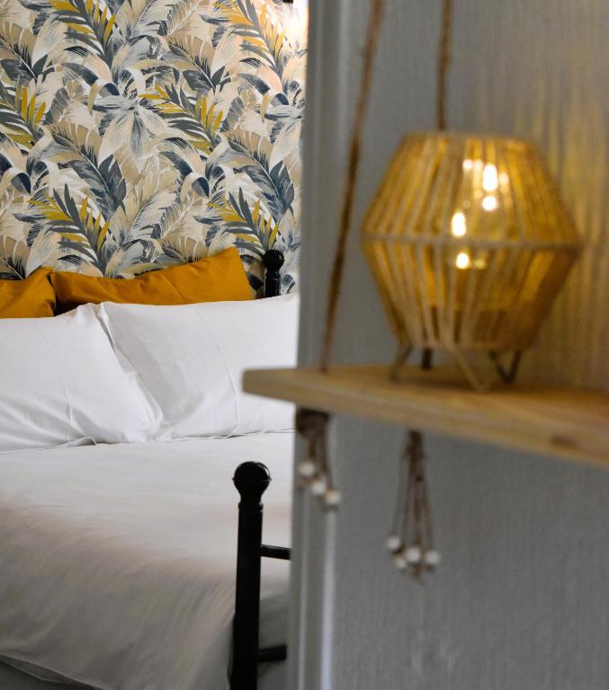 une chambre avec un lit et une lampe sur une table dans l'établissement Le Côteau du Segala, à Villefranche-de-Rouergue