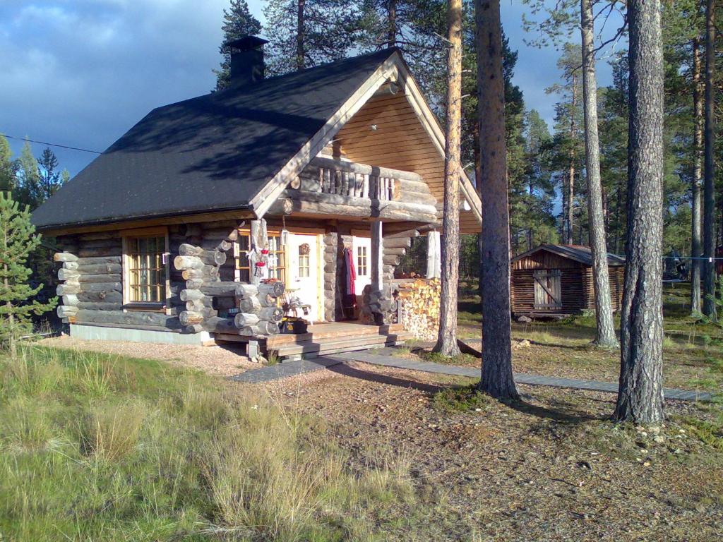 a small log cabin in a field with trees at Ranta Äärelä in Vuotso